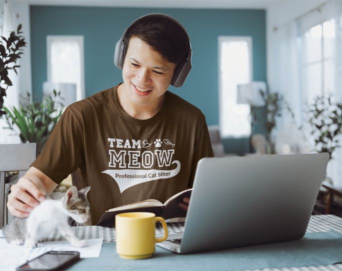 Pet sitter with cat in front of computer