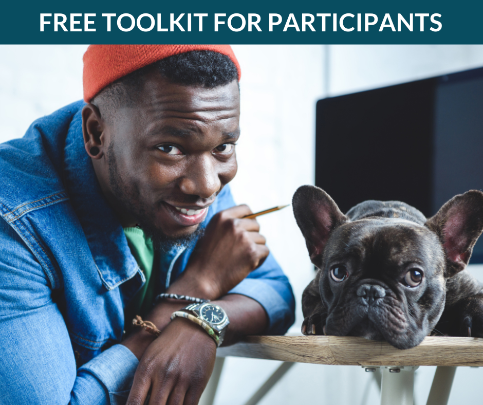 A creative professional smiles at the camera while a dog sits next to him.