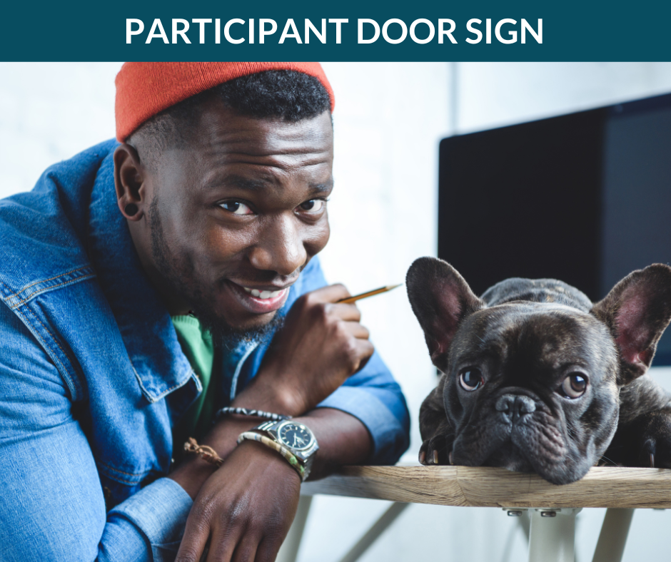 A creative professional smiles at the camera while a dog sits next to him.